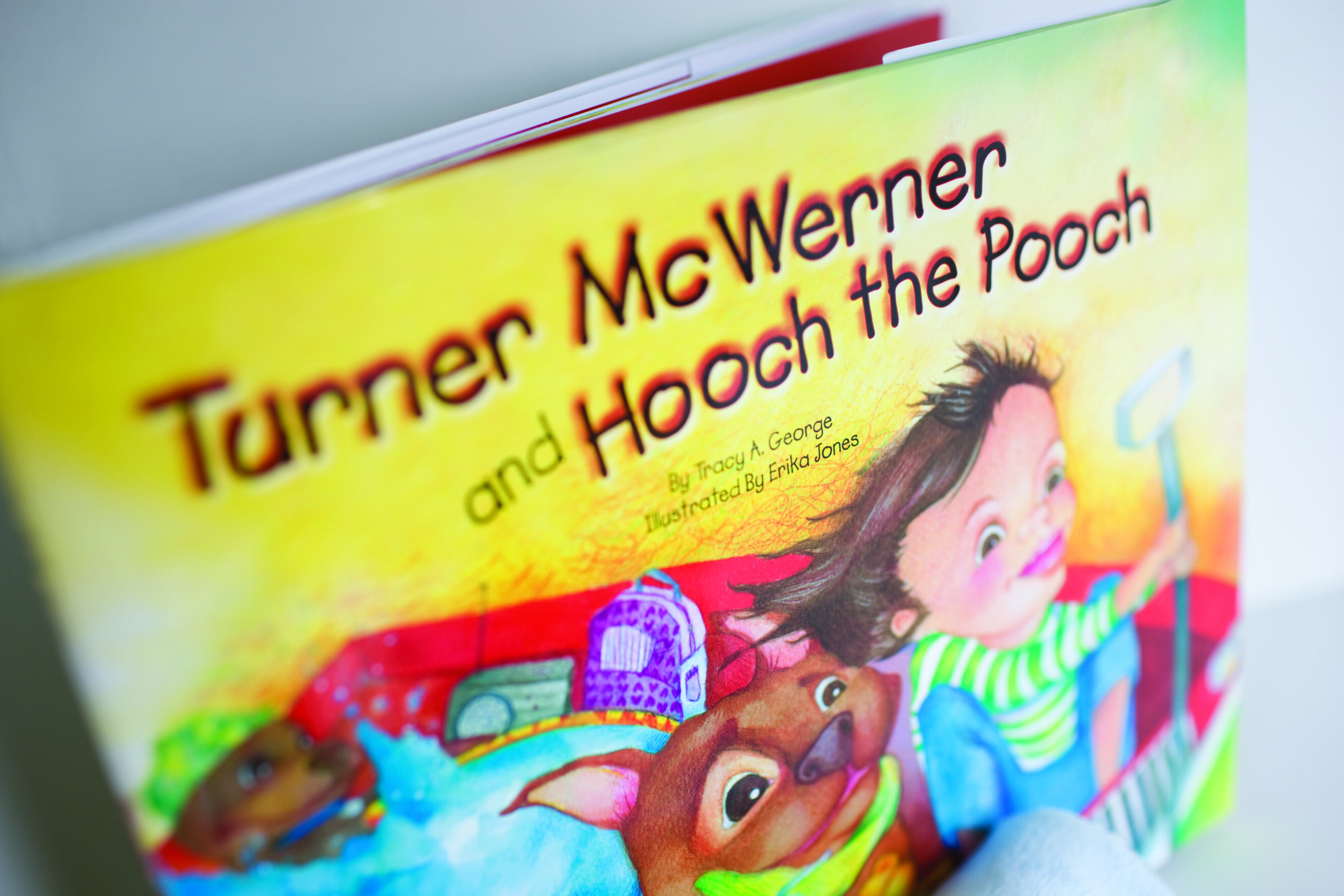 Turner McWerner-Angle Close-up of a colorful children's book titled Turner McWerner and Hooch the Pooch by Tracy A. George featuring illustrated characters of a child and a dog, reflecting Tracy George’s storytelling and artistic creativity.
